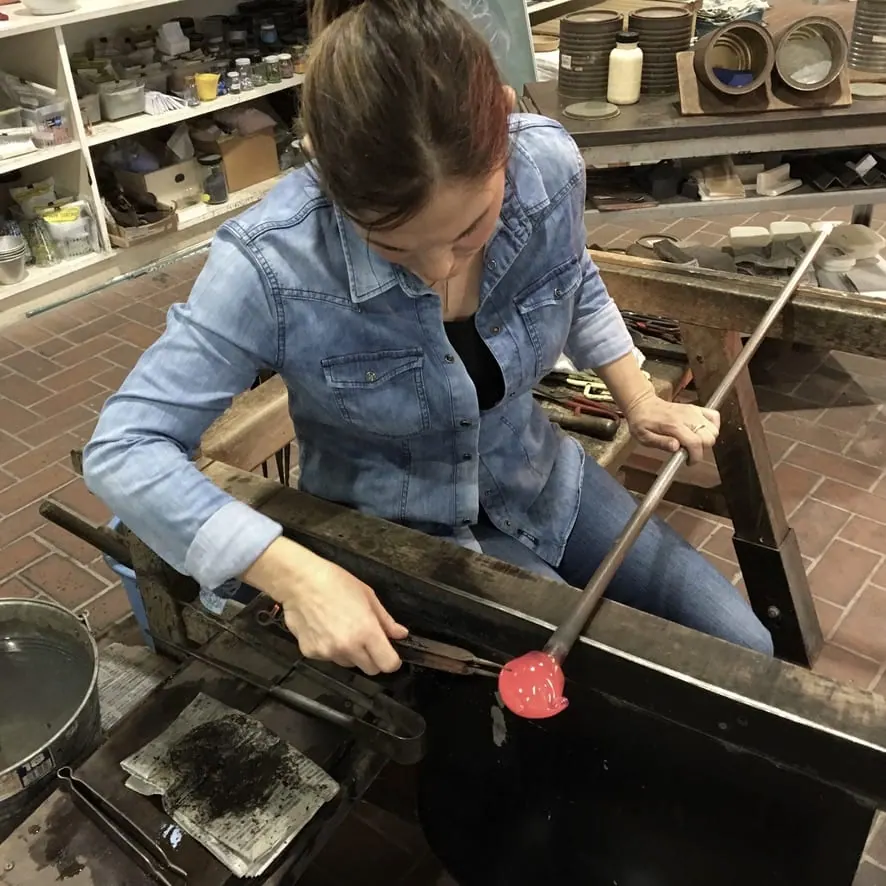 Elzbieta Larsten shaping hot glass at the bench